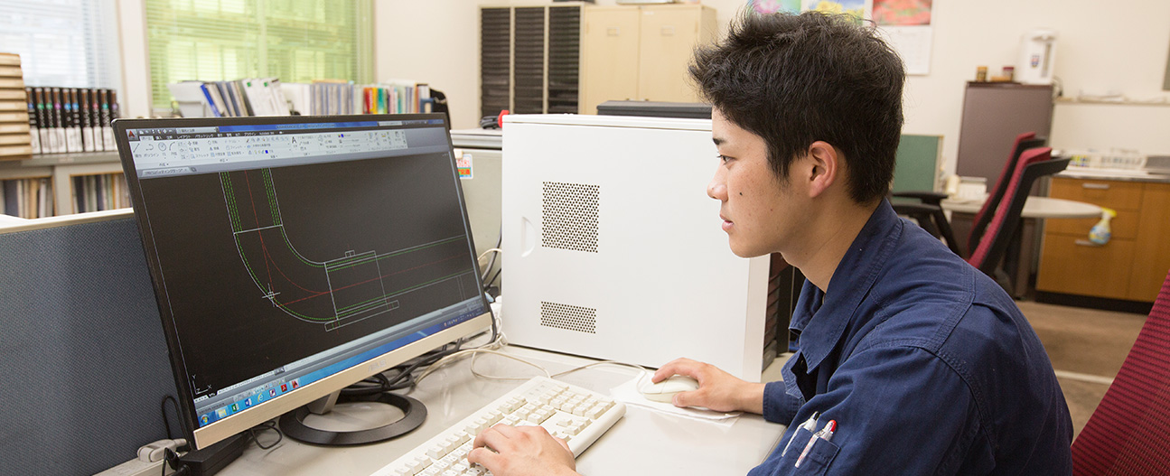 写真：パソコンの画面に向かって図面を制作する男性社員